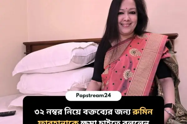 একজন মহিলা লাল শাড়ি পরা অবস্থায় একটি বিছানায় বসে আছেন, পেছনে সাদা বালিশ দেখা যাচ্ছে। ছবির নিচে বাংলা লেখায় লেখা আছে: "৩২ নম্বর নিয়ে বক্তব্যের জন্য রুমিন ফারহানাকে ক্ষমা চাইতে বললেন সাংবাদিক ইলিয়াস হোসেন"।